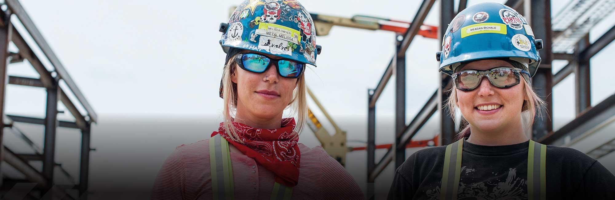 two women with hard hats and reflective glasses