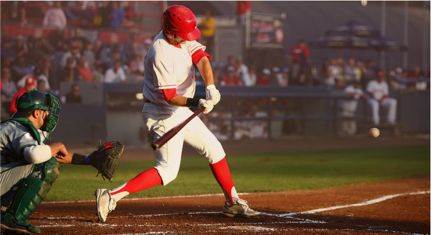 Baseball player swinging at a pitch at the ballpark