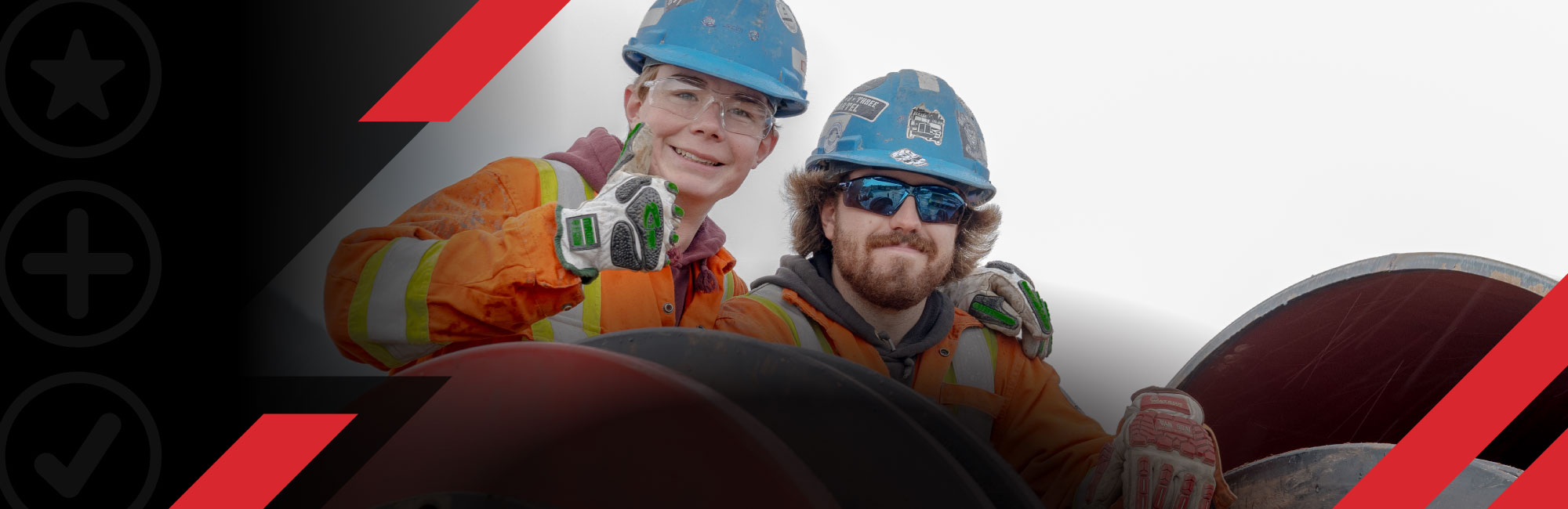 two workers on a pipe in front of mountain