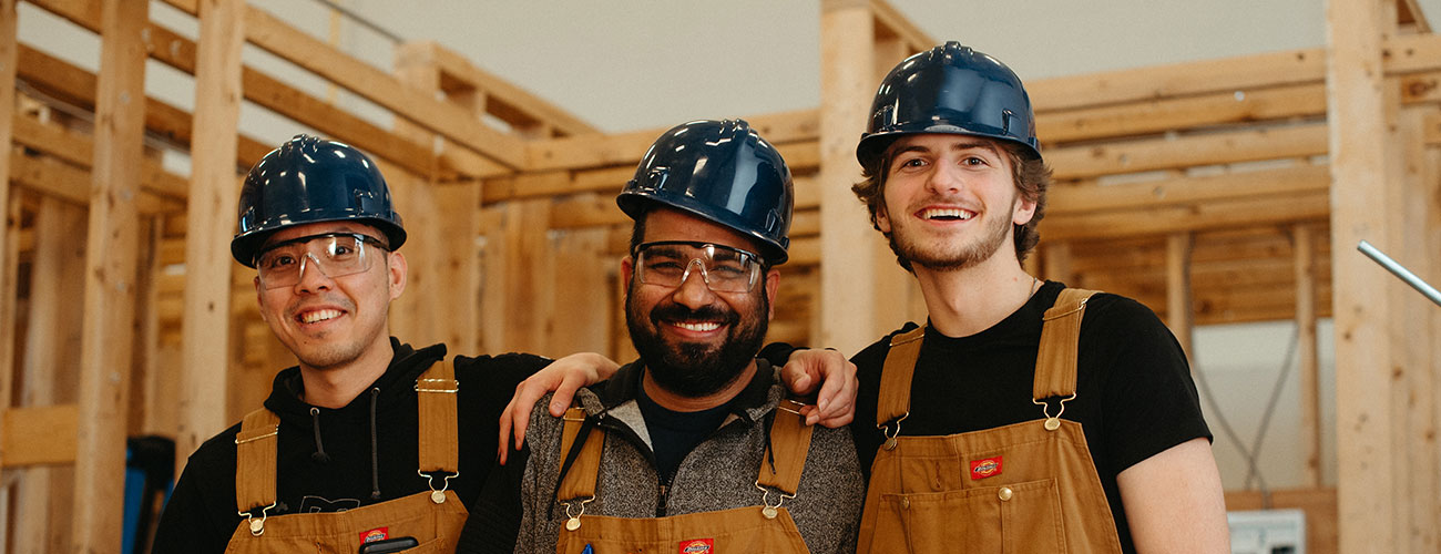 three people embracing in a work shop