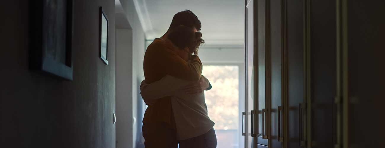 two grieving people in an embrace