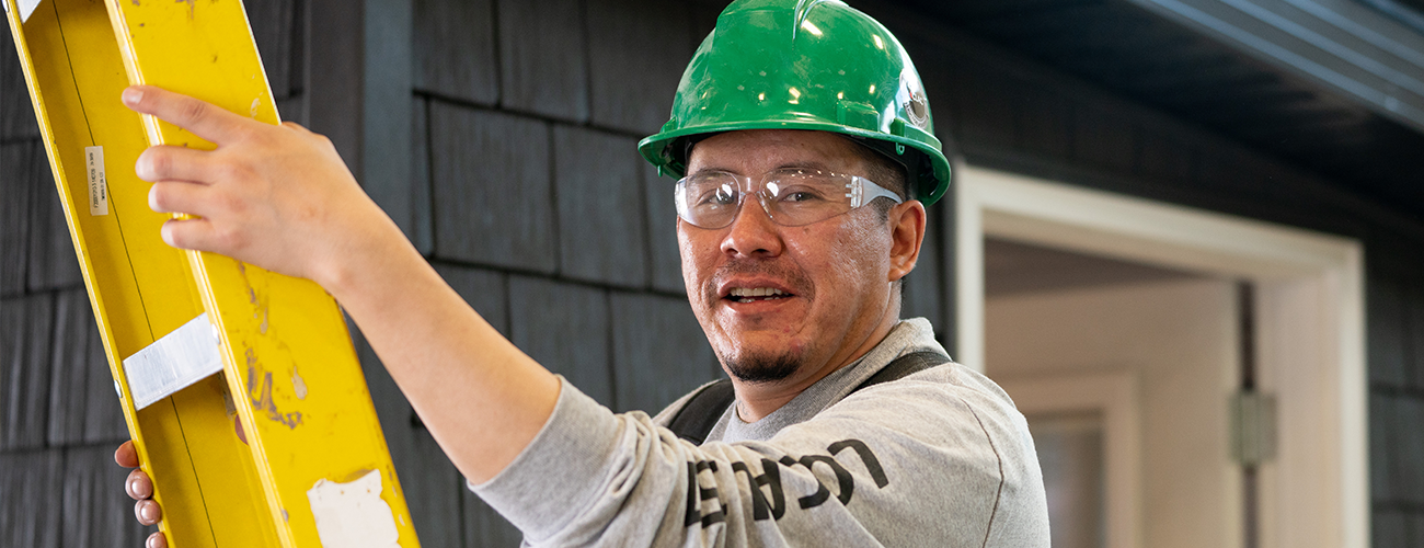 man wearing hard hat on ladder